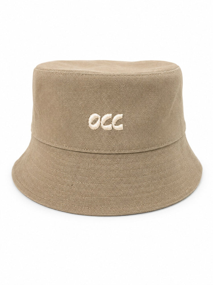 A beige bucket hat made of textured canvas fabric, featuring the letters 'occ' embroidered in white on the front, set against a plain white background.